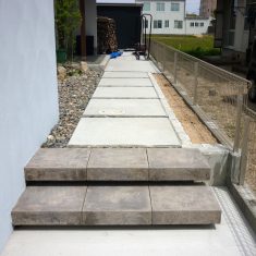 アプローチ手前にある階段はＴＯＹＯの「ダルストーンステップ」という舗装材で浮遊感のある階段に仕上がっています。アプローチ右側に植栽スペースを設けています。